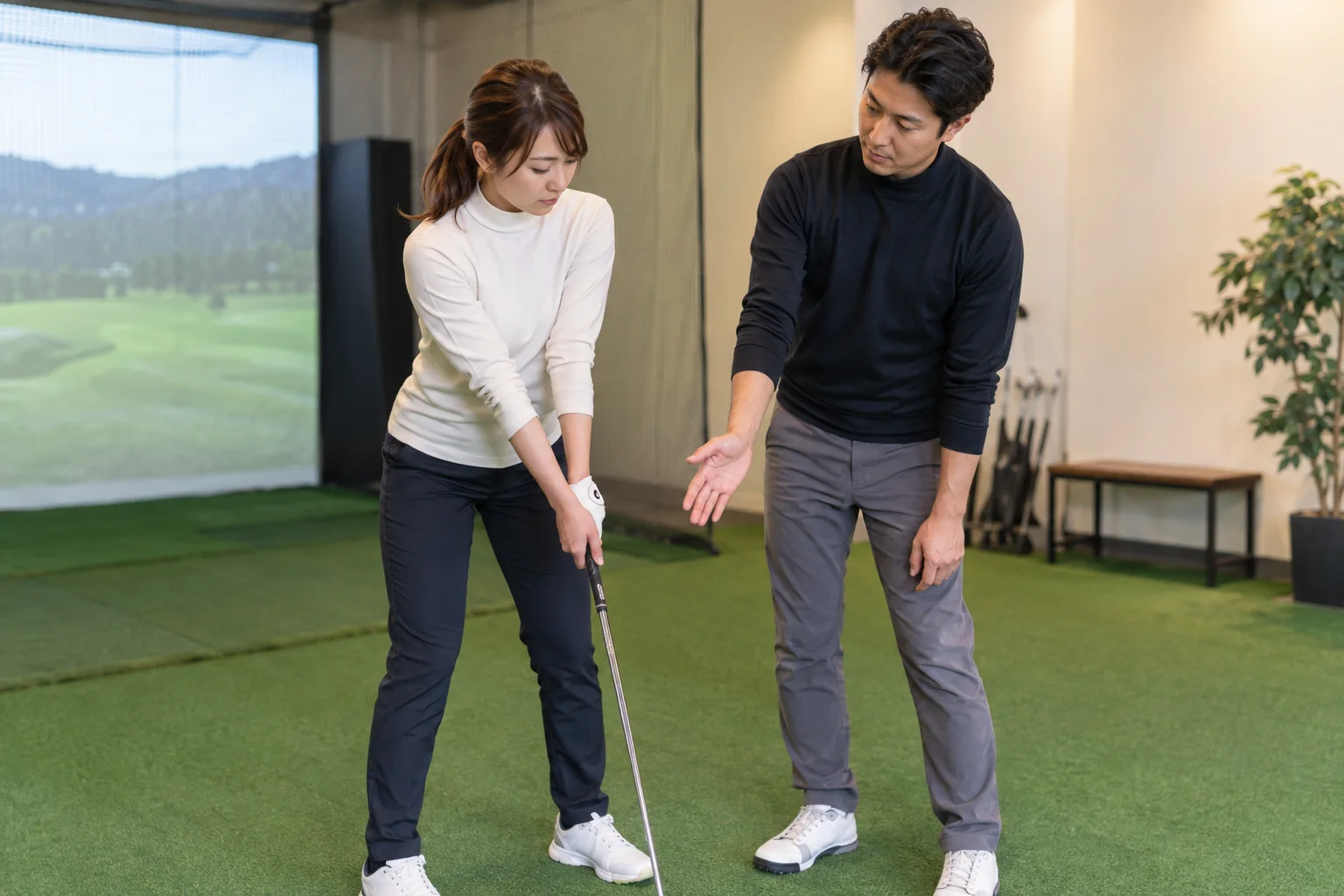 コーチと受講者がクラブの握りを確認している様子