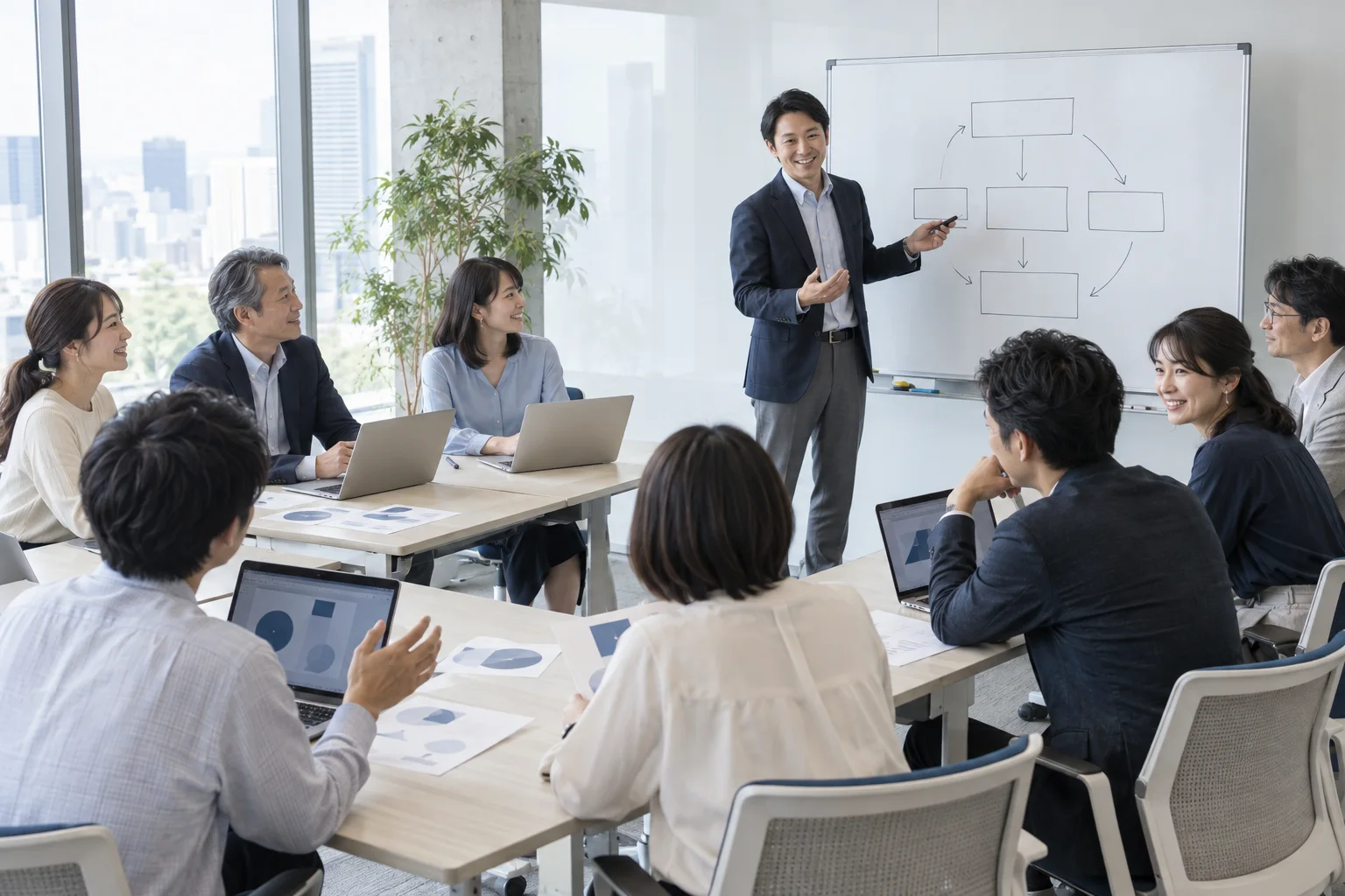 ホワイトボードの前で社内勉強会を進めるコンサルタント