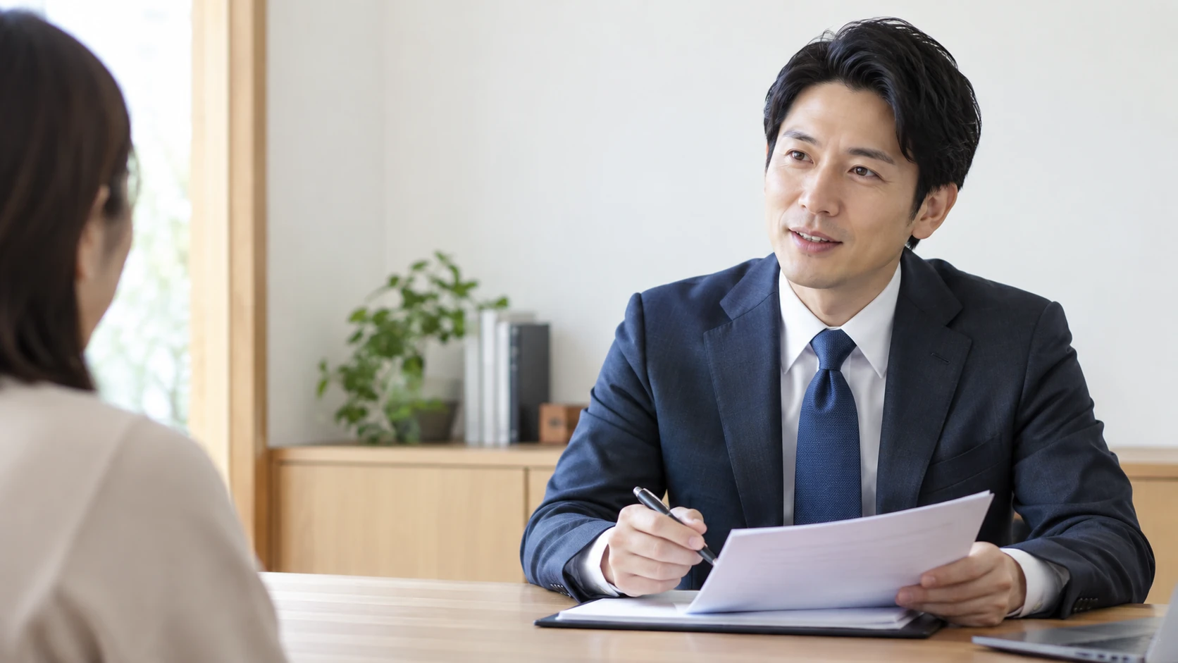 木の机を挟み、穏やかに話を聞く担当者