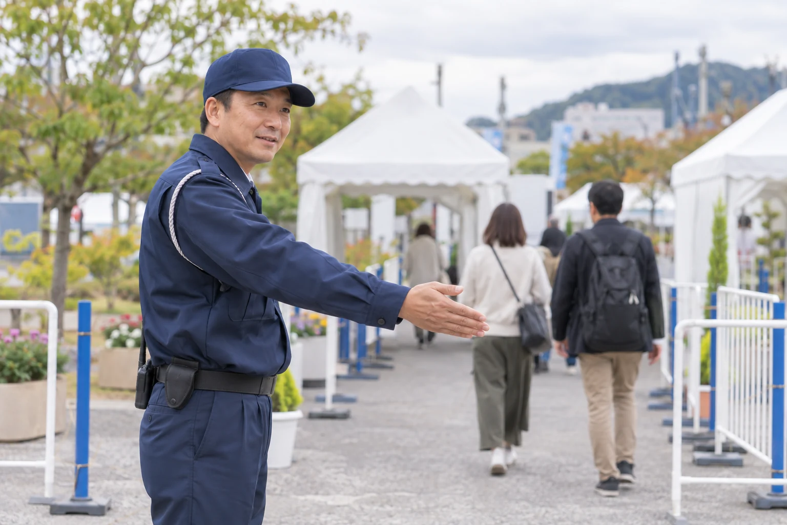 屋外イベントで来場者を案内する警備員