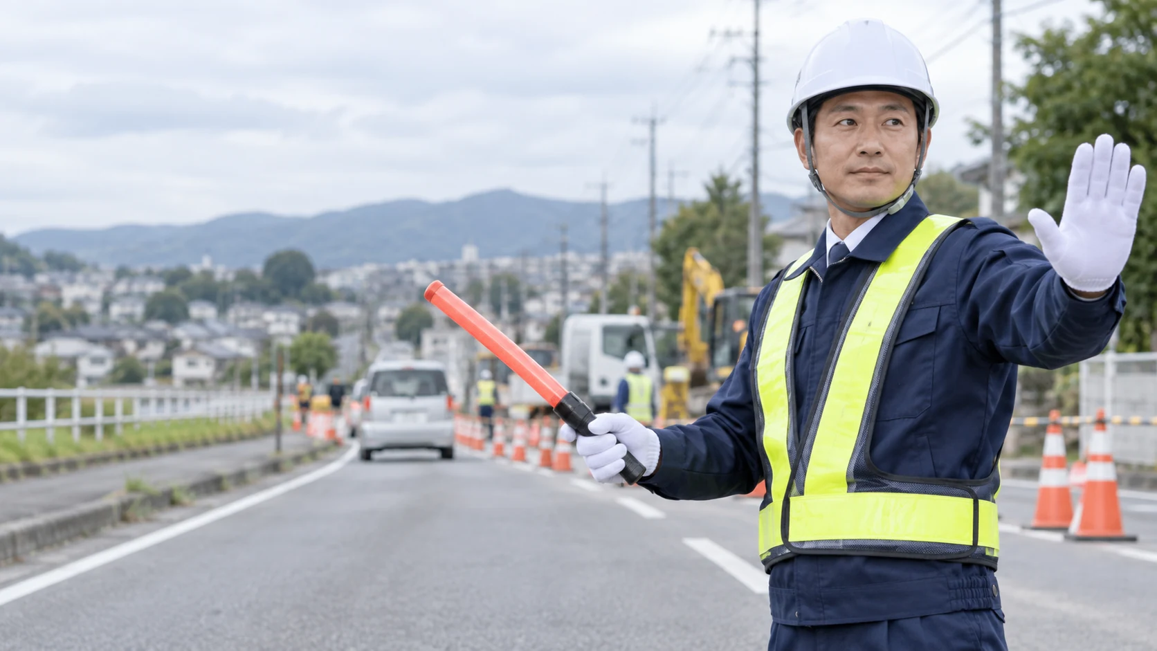 道路で車両と歩行者を誘導する警備員